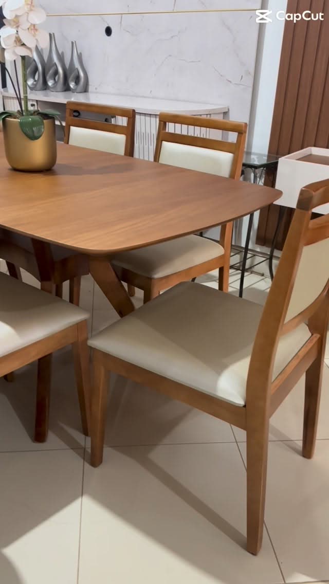 Mesa de jantar de madeira maciça com cadeiras estofadas no showroom da Móveis Pires